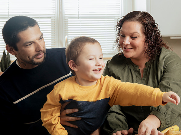 Father and Mother with their toddler son at the kitchen table