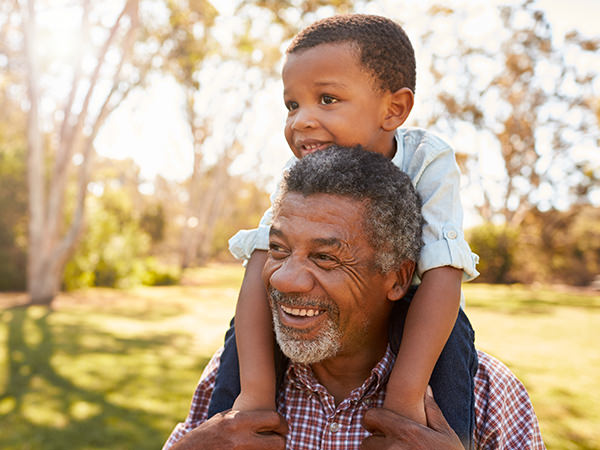 Grandfather carrying grandson on shoulders