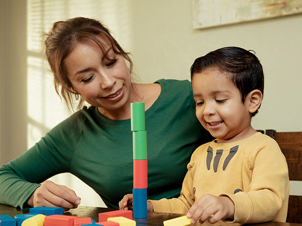 Mother and son playing with blocks of shapes