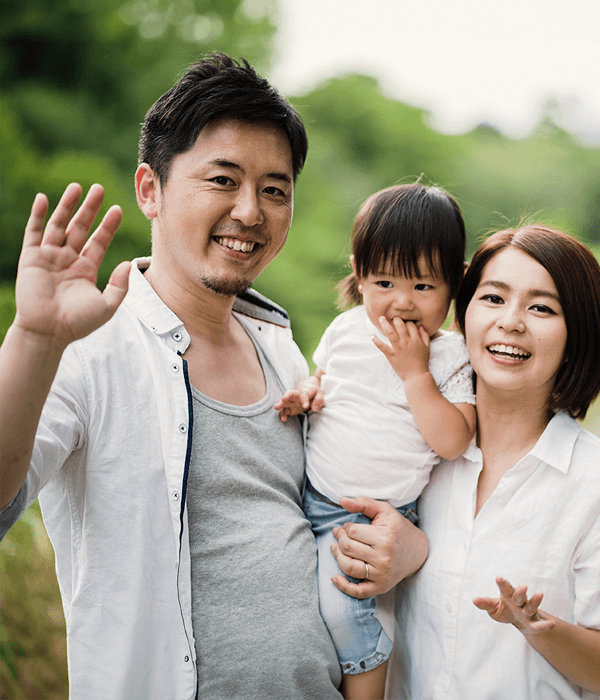 Parents waving and carrying toddler